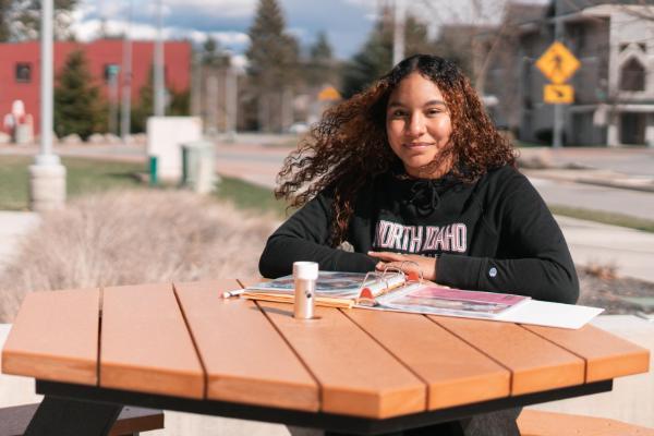 Student outside sitting at a table