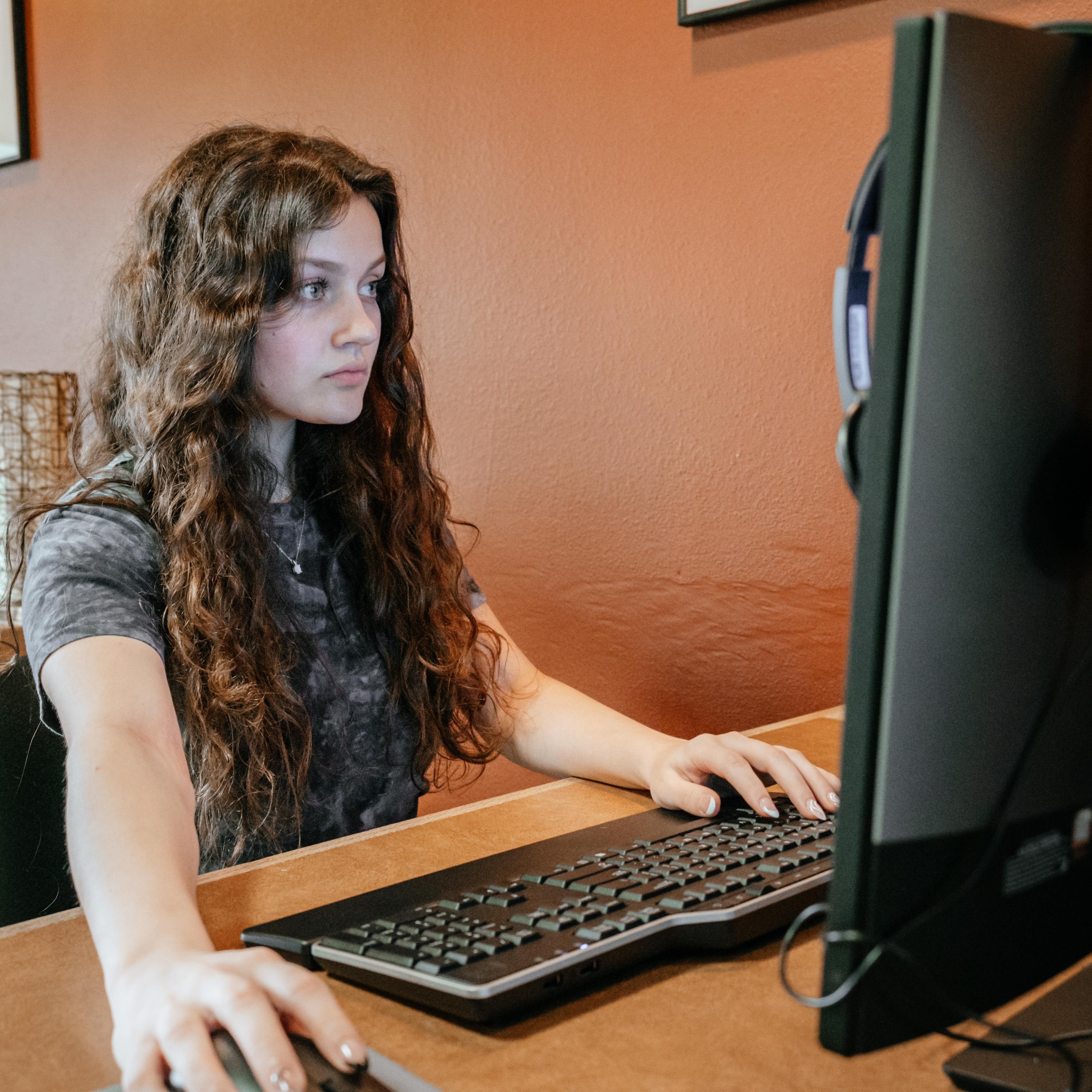 student at desk working at computer