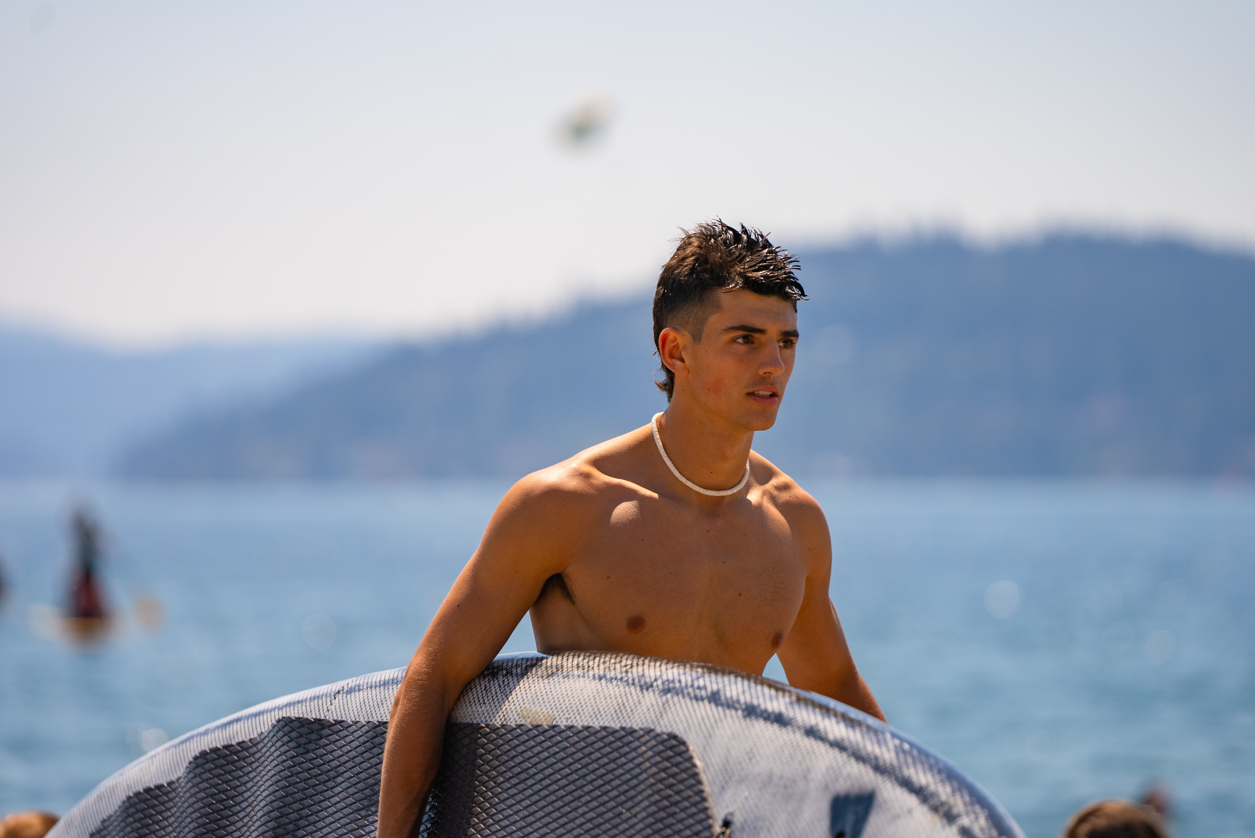 Male walking holding a paddleboard