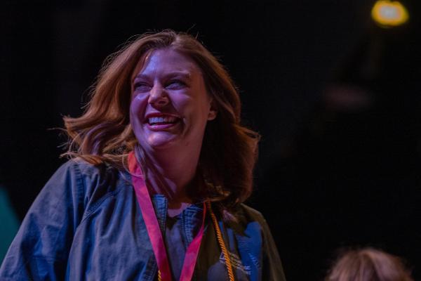  Smiling female student walking across stage