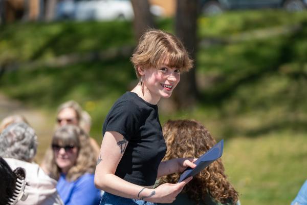 Female student smiling holding a folder