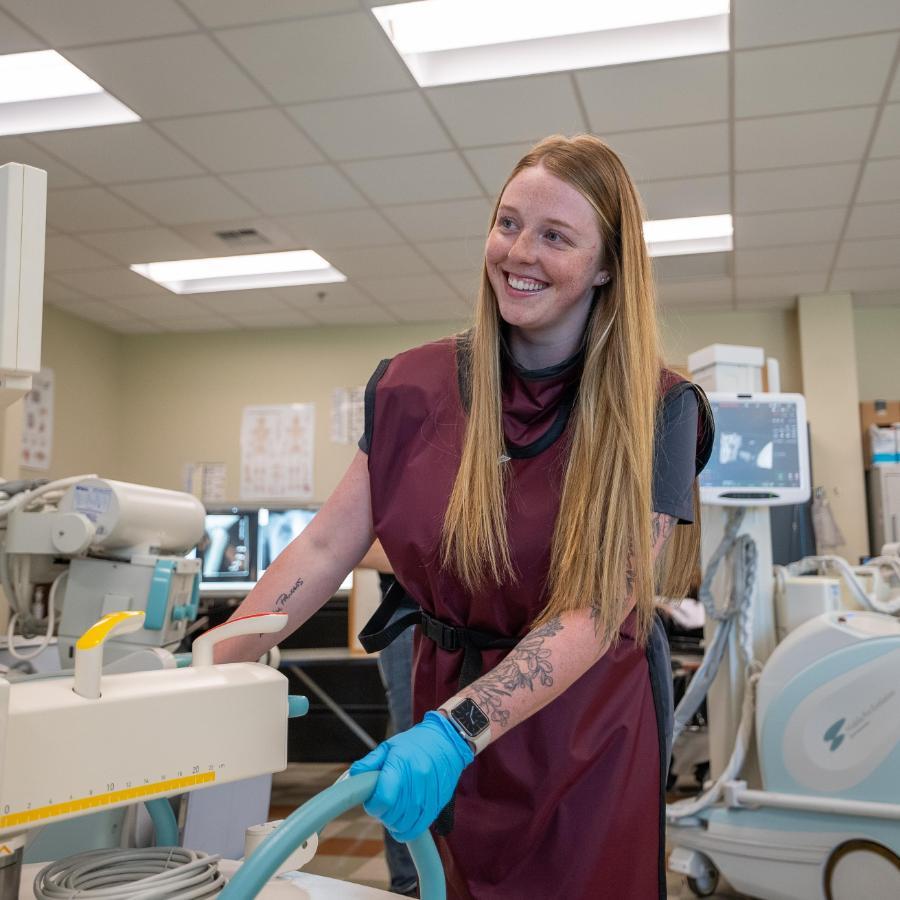 Rad tech student smiling using machine