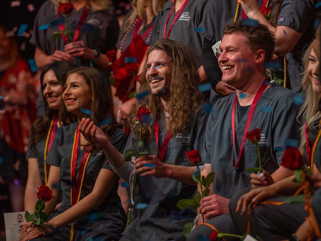Johnathan Aston of Post Falls reaches for confetti onstage during the NIC Nursing program's pinning ceremony Wednesday, May 10 in Boswell Hall Schuler Performing Arts Center on NIC’s Coeur d’Alene campus.