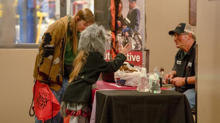 NIC Automotive Professor Mark Magill talks to people visiting his table at the Career and Technical Education Trick or Treat Open House on Oct. 27, 2023 at the Parker Technical Education Center in Rathdrum.