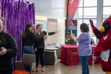 Women at Work participants pose in front of a photo backdrop on April 16, 2024, at the Parker Technical Education Center in Rathdrum.