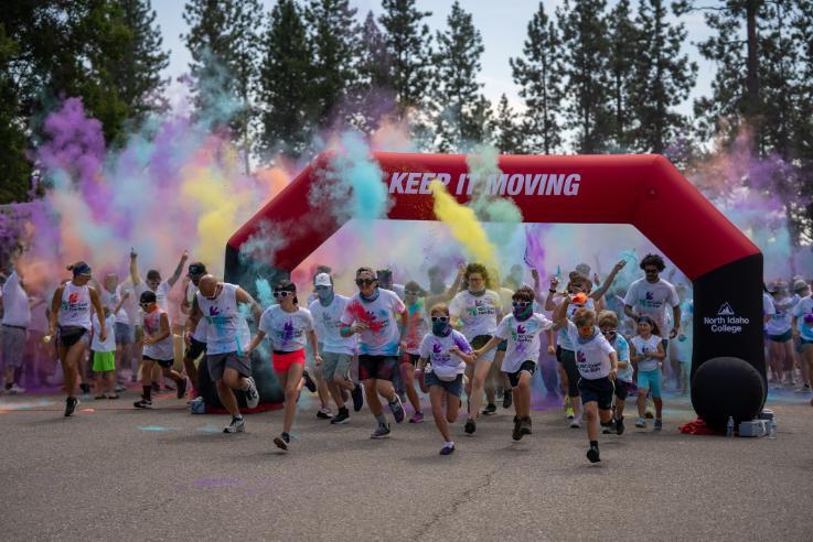 Participants run through the start line of the inaugural NIC Color Fun Run on Aug. 23, 2025.