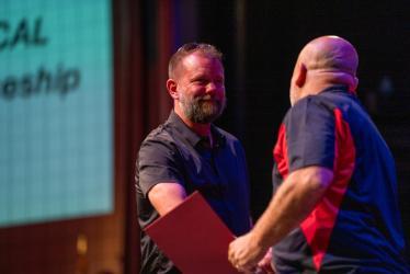 North Idaho College Workforce Training Electrical Apprenticeship Instructor Greg Pratt shakes the hand of apprenticeship graduate Mark Sylva.