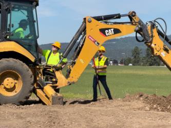 A North Idaho College Workforce Training Center heavy equipment operation instructor speaks to a student learning to dig with a backhoe Friday, June 15 at the NIC Parker Technical Education Center in Rathdrum.