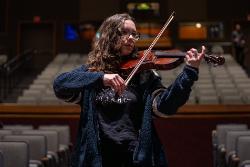 NIC female student playing the violin