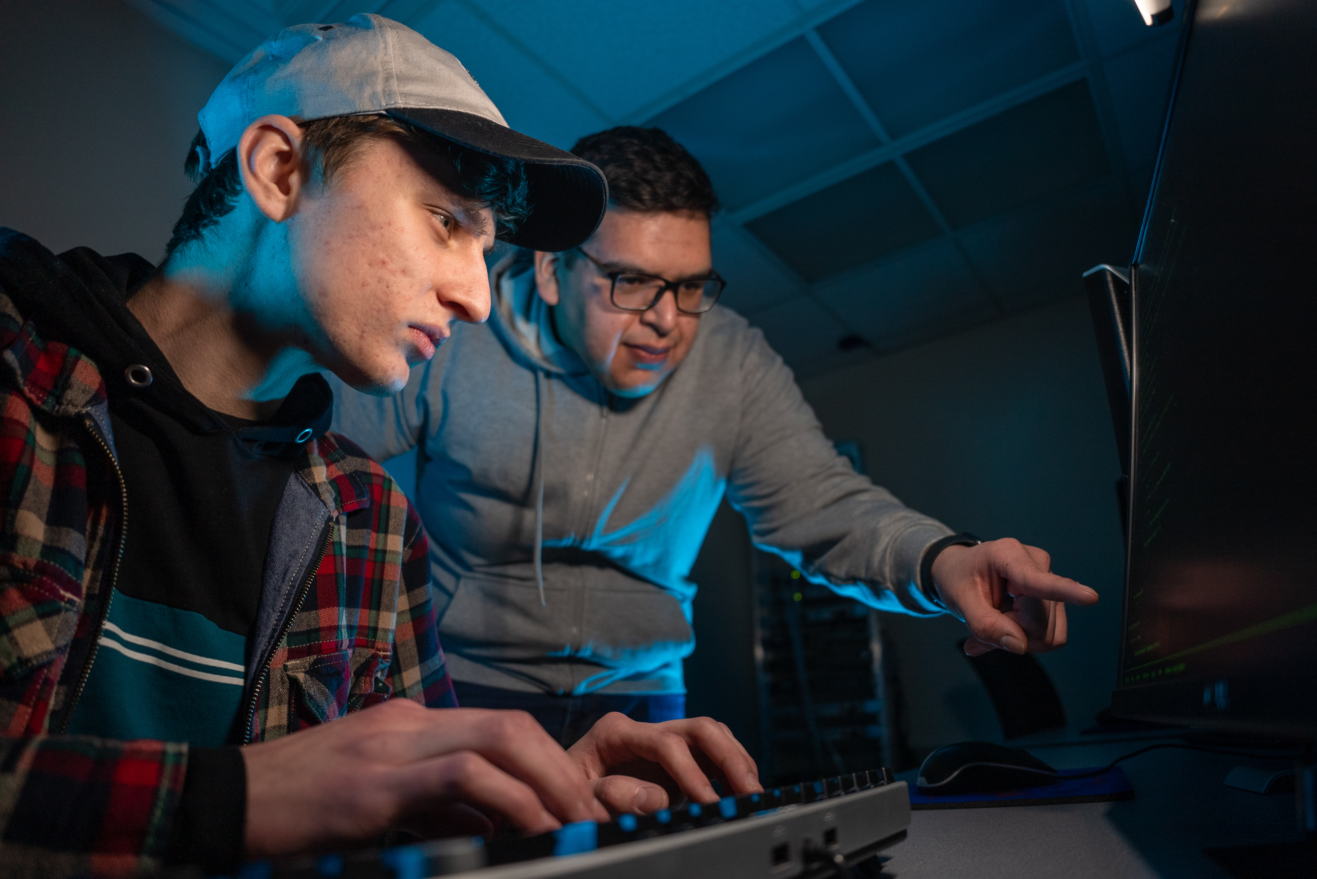 Student and professor looking at a computer screen