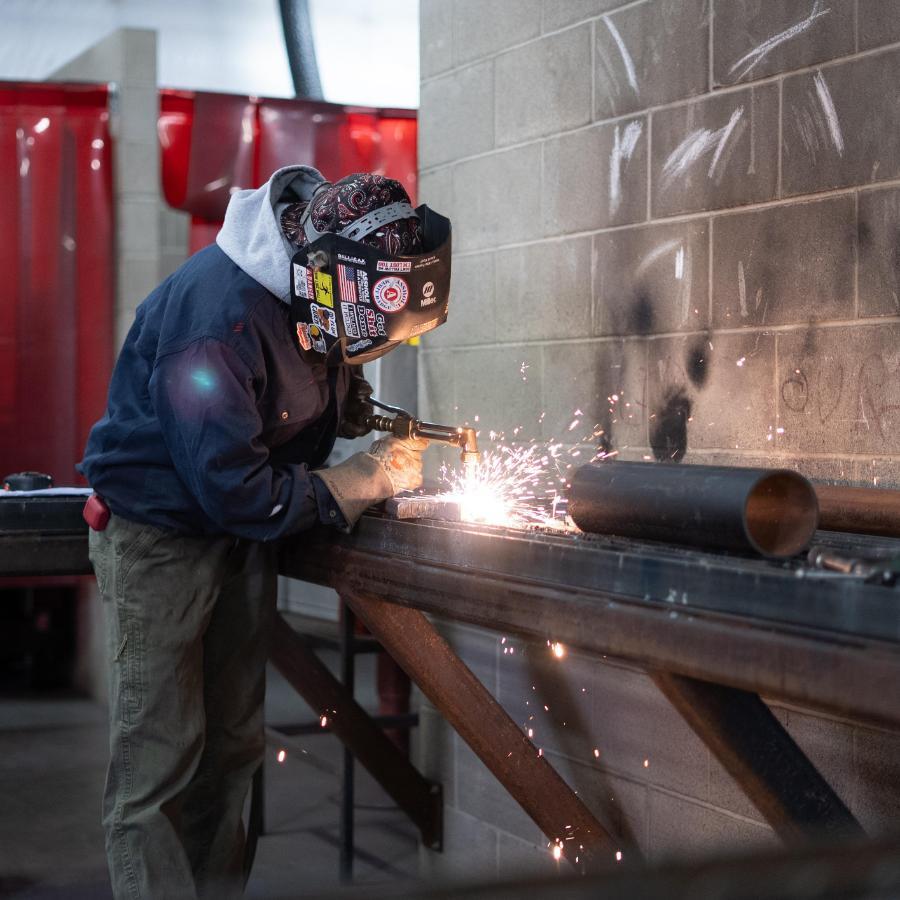 student welding on a table in welding class