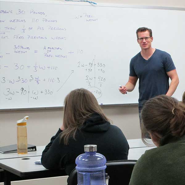 Professor teaching math in front of class